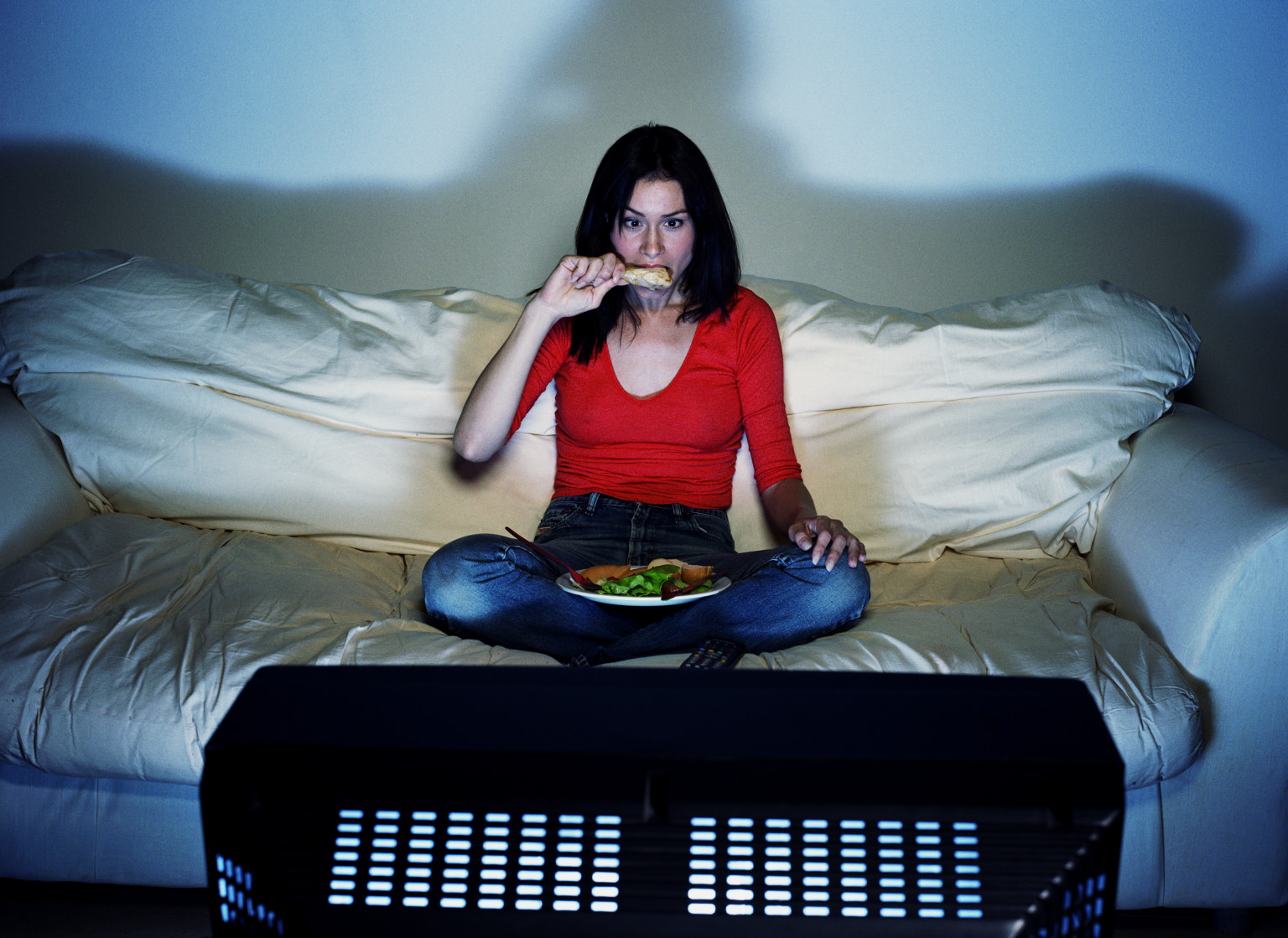 woman eating and watching television